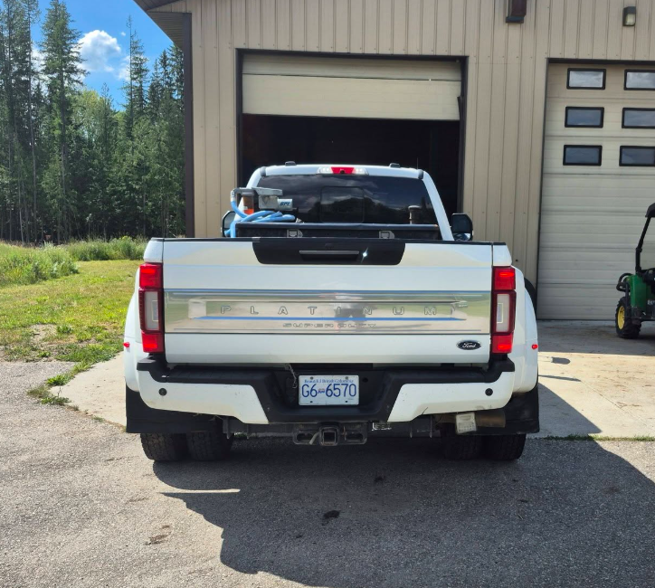 Detailed white Ford truck tailgate parked outside a shop